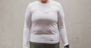 Animation of spots of light over plus size caucasian woman in sports clothes flexing muscles. Sports, active lifestyle, urban living and happiness concept digitally generated video.