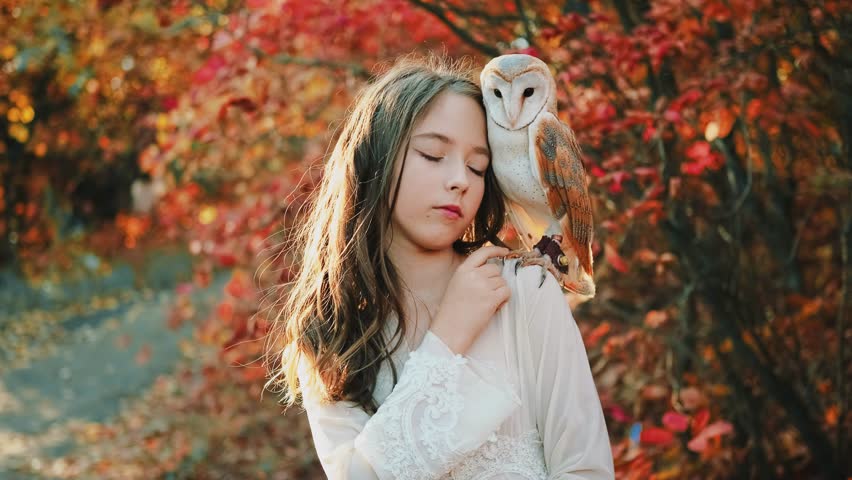 Fantasy girl princess with white bird barn owl on shoulder. Fairy tale young woman Beauty face eyes closed enjoying calm relax listening to sounds of autumn nature forest red trees. vintage dress 4k Royalty-Free Stock Footage #1108157321