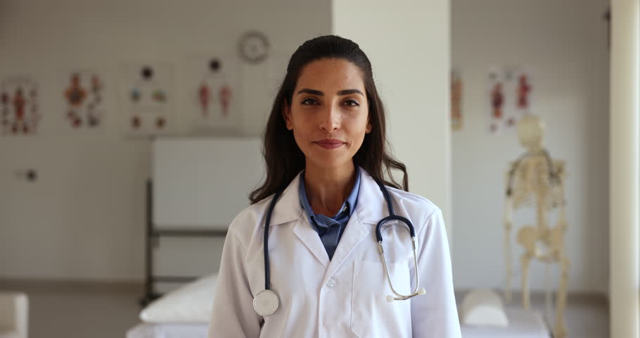 Portrait smiling positive Latina female cardiologist in white medical uniform pose at workplace showing heart shape with joined folded fingers. Cardiology, cardiovascular disease prevention, medicine Royalty-Free Stock Footage #1108158047