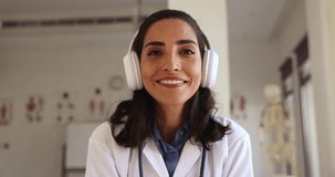 Close up portrait happy Latina general practitioner start video call to patient at workplace, provide professional medical aid, consult on-line use videoconference application. Modern tech, e-health