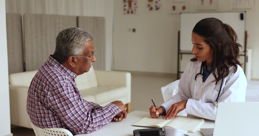 Young 35s female professional doctor consulting old male patient, talking to senior man client during consultation, medical health check-up visit in hospital. Geriatrics, diseases treatment, eldercare Royalty-Free Stock Footage #1108158097
