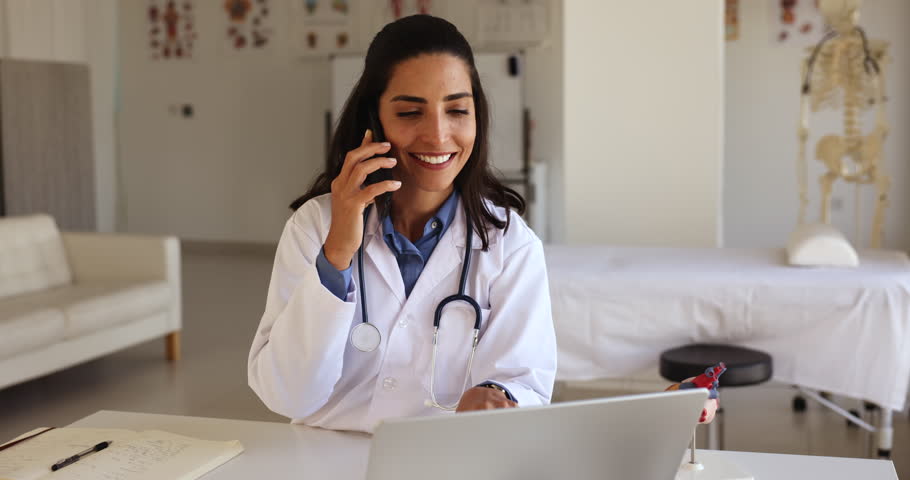Young Latina female medical practitioner sit at desk looks at laptop explain recommendation, discuss checkup results to patient by phonecall, work in clinic office use modern tech. Healthcare, talk Royalty-Free Stock Footage #1108158145