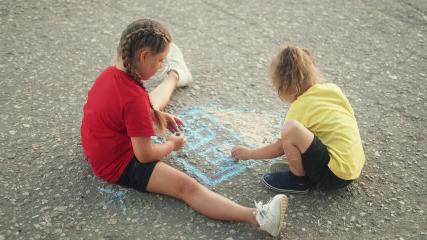 Happy child draw with chalk on asphalt in park. Child play and paint house and sun. Happy family concept Dream of home. Kid dream in park. Concept of kid dream of home. Chalk drawing of sun