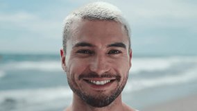 Portrait of One Young Man Looking at Camera on Water Waves Background. Beautiful Eyes and Happy Face of Smiling Male Person Standing at Sunny Outdoors. Optimism of Successful Adult Boy at Sun Beach - Powered by Shutterstock - Get 15% off with code: PIKWIZARD15
