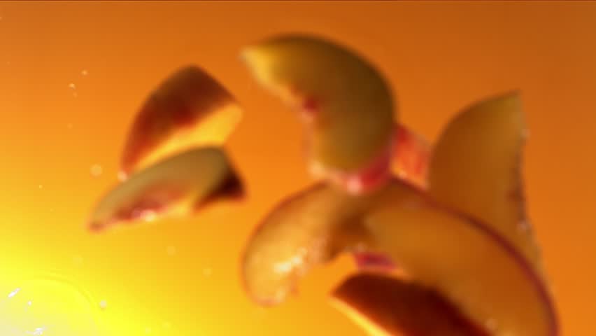 Super Slow Motion Shot of Fresh Peaches Falling into Juice Whirl