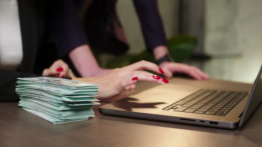 Portrait of a young woman and a business man sitting at a table late in the office in front of an open laptop and managing the company's finances and expenses. Royalty-Free Stock Footage #1108165175