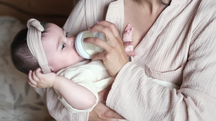 Inclusive Mothering: As baby feeds from a bottle in his mother arms, every mother journey is unique, and each decision, including how to feed, is deeply personal and valid. Royalty-Free Stock Footage #1108172141