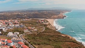 Aerial view of Beautiful tourist city in Portugal with ocean shores with azure water. Travel and summer holiday concept. Video shooting from a drone of a famous portuguese touristic city on summer. 