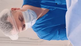 Doctor and assistant of the venous vascular surgery clinic during leg surgery. Vertical video