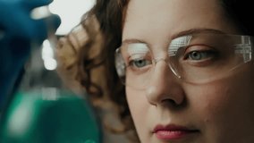 Specialist. Middle-aged woman Eyes of a lab worker look at a chemical liquid In an experiment room. Young professional develops a vaccine In a modern scientific center, transparent - Powered by Shutterstock - Get 15% off with code: PIKWIZARD15