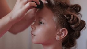 A make-up artist does professional makeup for a little girl, makes up before an event, the life of a celebrity or blogger,model. High quality 4k footage