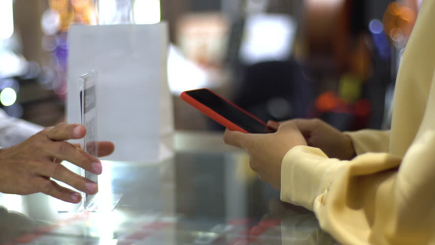 An upwardly mobile Asian Muslim woman using a mobile phone to scan the QR Code to pay for a product at a sale terminal identification payment for verification and authentication Royalty-Free Stock Footage #1108178803