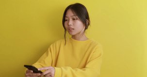 sad unhappy Asian teenager in sweater testing checking new smart phone camera Young woman learning to taker selfie, looking at screen Gadget Girl sending her photo to friend, online chat, acquaintance