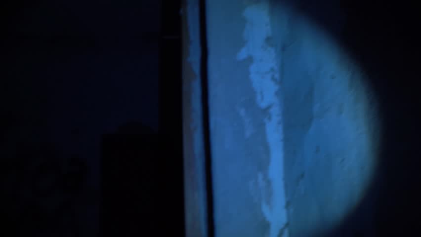 Portable flashlight glowing in the dark on the words HELP ME written in blood