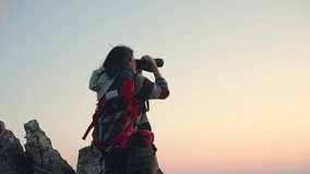 4K Asian woman traveler standing on mountain peak and using binoculars looking beautiful nature at sunset. Attractive girl enjoy adventure outdoor lifestyle travel nature and hiking on summer vacation - Powered by Shutterstock - Get 15% off with code: PIKWIZARD15