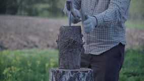 a man splits a wooden log with an axe - stock video, harvesting firewood for stove