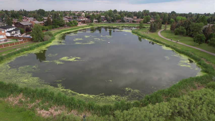 Aerial footage of Lakeview, Saskatoon, SK, highlighting its serene lakeside homes, winding streets, and expansive green spaces. A tranquil neighborhood oasis, perfect for real estate  nature visuals.