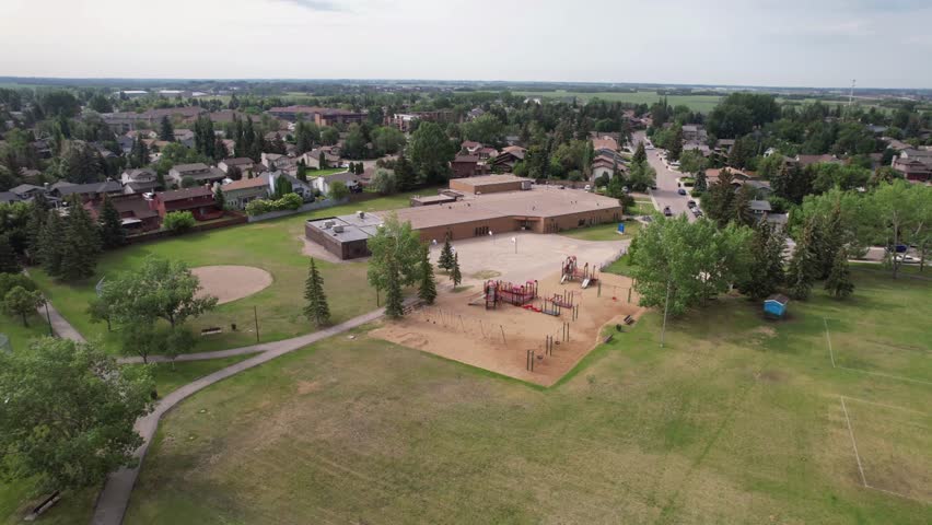 Aerial footage of Lakeview, Saskatoon, SK, highlighting its serene lakeside homes, winding streets, and expansive green spaces. A tranquil neighborhood oasis, perfect for real estate  nature visuals.