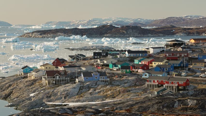 Panning shot of arctic settlement above Arctic Circle against the backdrop of glaciers and icebergs. Village with colorful houses - Ilulissat, Greenland. Nature of Greenland Royalty-Free Stock Footage #1108196373