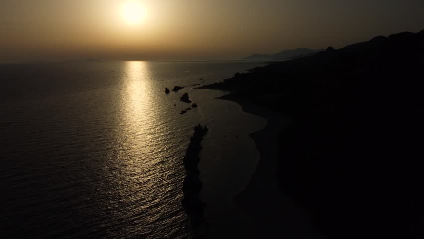 Aerial view of the wild sea beach at the sunset on the Ionian coast in Greece. Top view from drone.