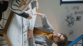 Male interior designer and female client shaking hands, then looking through catalogs and discussing materials and colors for a project during meeting in the office. Vertical format clip