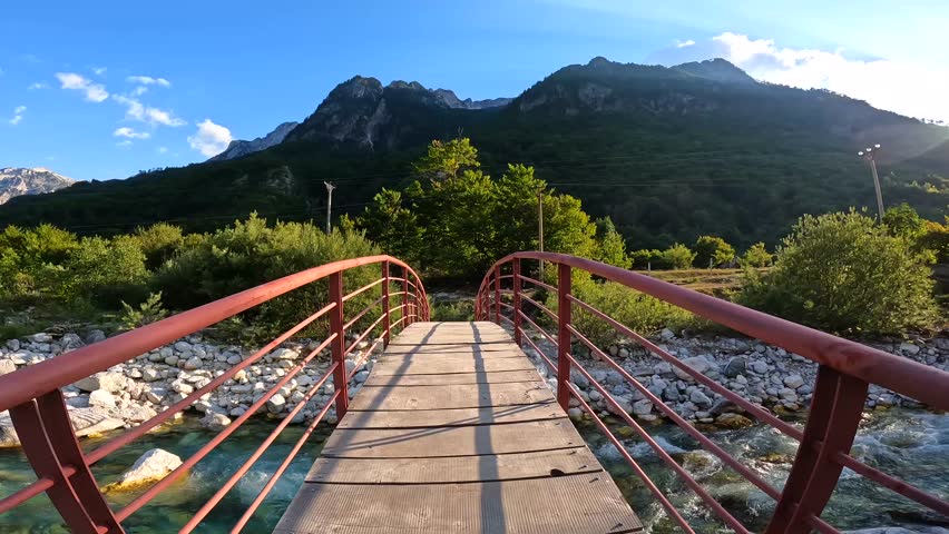 Sunset on the red bridge above the turquoise water river of Valbona valley, Theth national park, Albanian Alps, Albania