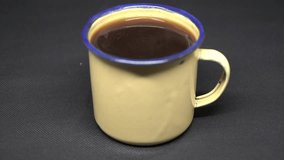 video of hot coffee in a small glass with a black background