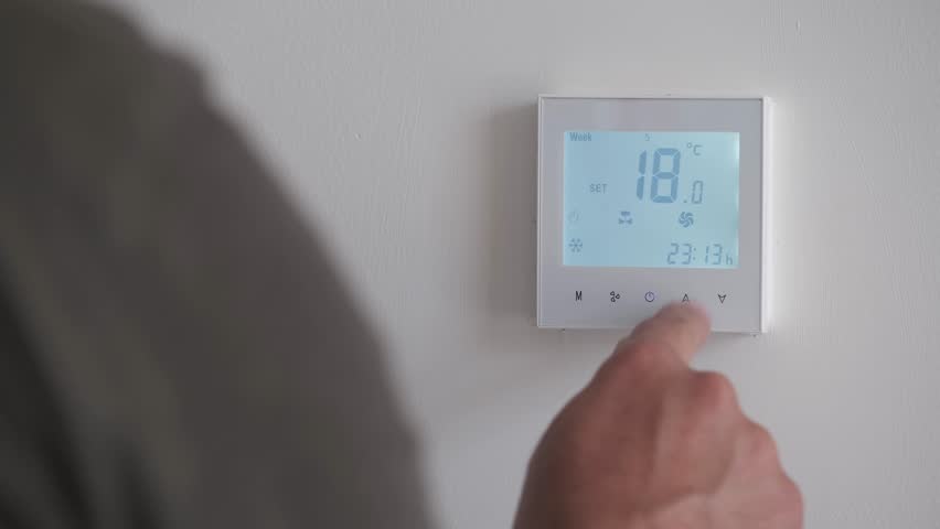 4K 24 fps, AC controller setpoint change footage showing a man decreasing the temperature set point.