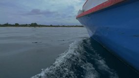 4K footage showing crusing boat at low angle over Java ocean