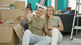 Man and woman couple having video call holding keys at new home