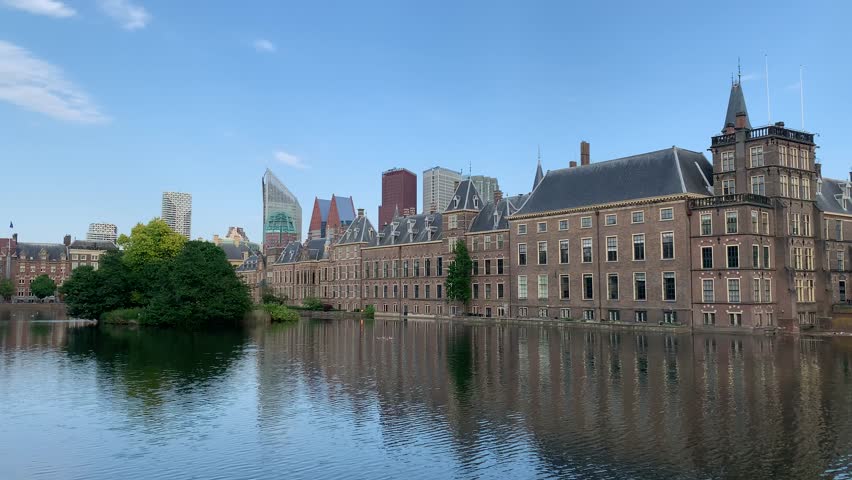View of Binnenhof complex. Dutch government, house of representatives and office of Prime minister. Den Haag city skyline. Motion of Hofvijver lake water. The Hague, South Holland, Netherlands