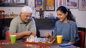 An old man with white hair is playing chess with his granddaughter - board game, generation gap, good care. A young girl in her early twenties spending time with her father - leisure time, family b... - Powered by Shutterstock - Get 15% off with code: PIKWIZARD15