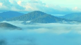 Sunrise paints the Ranong Province, Thailand tropical forest with a tranquil beauty as a delicate veil of morning fog gracefully blankets the landscape. from a drone, nature awakens in misty splendor.