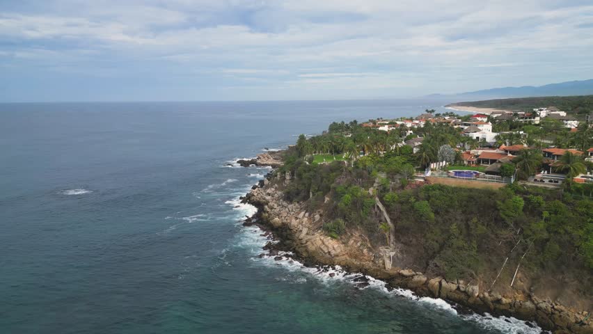 Above the coastline houses, aerial view of Carrizalillo and Bacocho beaches at Puerto Escondido, Oaxaca, Mexico