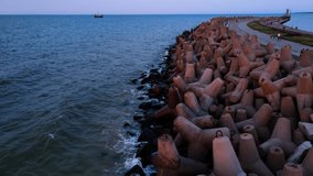 Waves break on concrete tetrapod breakwaters at sea coast. Protection from large waves. Baltic Sea coast at Wladyslavovo port at sunset - Powered by Shutterstock - Get 15% off with code: PIKWIZARD15