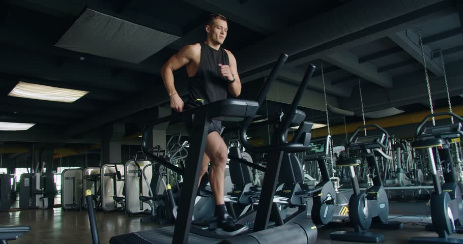 Strong athletic man doing intense cardio workout and running fast on treadmill at fitness club. Active sportsman male jogging at modern gym. Healthy lifestyle concept Royalty-Free Stock Footage #1108232825