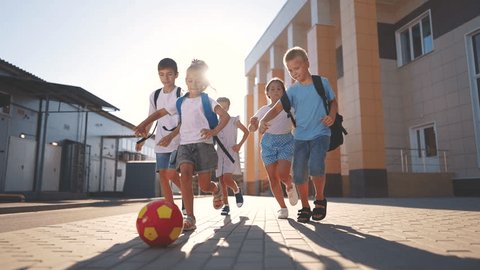 children near the school playing soccer. kids a school education kid dream concept. a group of children near the school playing ball. group of school children playing lifestyle soccer Video Stok