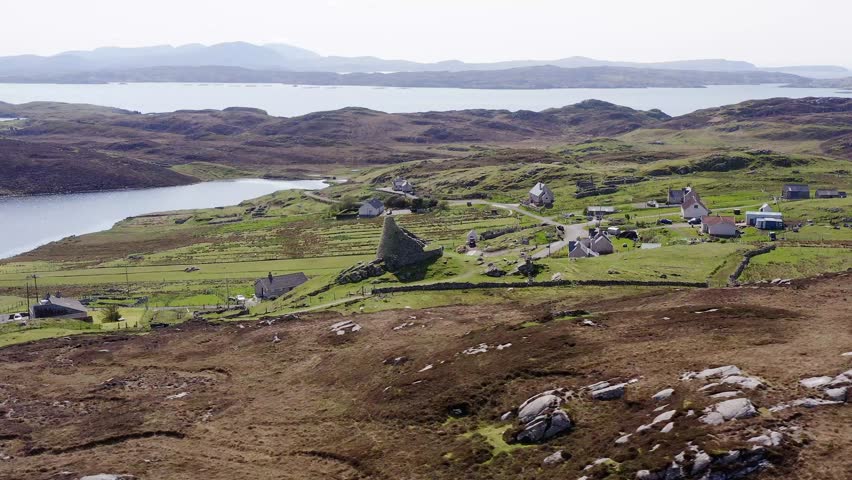 Wide angle drone shot of the 'Dun Carloway Broch' on the west coast of the Isle of Lewis, part of the Outer Hebrides of Scotland. The broch is a tourist attraction first built around 100AD.