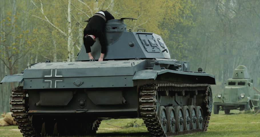 After Battle. Re-enactor Dressed As Dead German Tank Crew Lies Slain On German Wehrmacht Light Panzer Tank In Reconstruction Of Battles World War Ii.