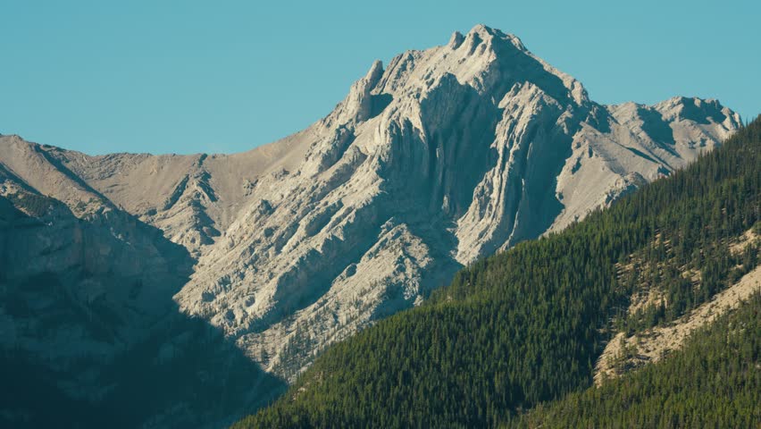 A Pastel Colored Symmetrical Interestingly Textured Mountain Cliff Face in the Rocky Mountains of Canada Under Blue Skies near Banff Alberta