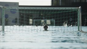 This video captures intense water polo counteraction as the goalkeeper anticipates the opposing team on goal in a recreational match. Concept of Summer Olympics, Olympic Games, Paris 2024