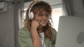 One caucasian woman with curly hair sit at home use digital tablet and headphones to watch movie or series online stream or to have video call happy smile have a good time copy space - Powered by Shutterstock - Get 15% off with code: PIKWIZARD15