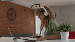 One caucasian woman with curly hair sit at home use digital tablet and headphones to watch movie or series online stream or to have video call happy smile have a good time copy space - Powered by Shutterstock - Get 15% off with code: PIKWIZARD15