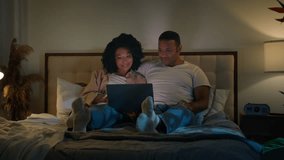 African American couple family man and woman in bed night home dark bedroom evening watching laptop tv movie watch film relaxing romantic date love relationship computer video shopping online together - Powered by Shutterstock - Get 15% off with code: PIKWIZARD15