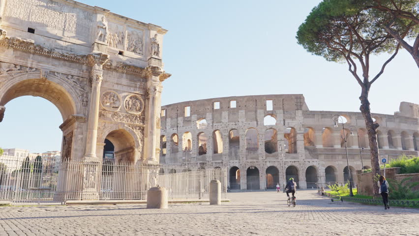 Asian male photographer, traveller walking among Colosseum the best known monuments architecture and landmark of Rome, Italy. Travel around the world with popular tourist destination background.