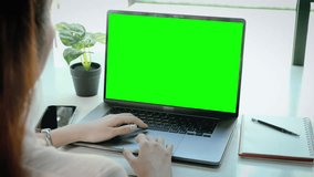 4K video. Woman using laptop computer notebook blank screen green monitor wallpaper for text advertising and copy space. 
