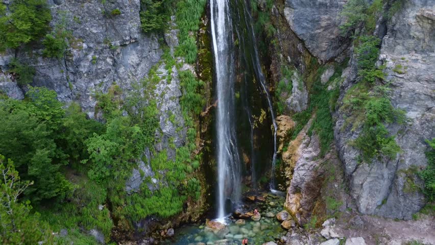 Aerial drone view of the waterfall in Theth national park, Albania. Walking away towards the waterfall