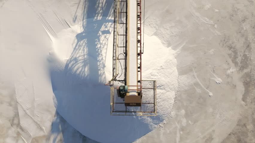 huge pile of salt conveyor belt moving sea salt produced by the evaporation of seawater.piles of white mineral salt and industrial equipment. Royalty-Free Stock Footage #1108275143