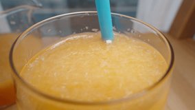 I stir the pulp in the glass of orange juice with a straw and take a sip, close-up, in slow motion. - Powered by Shutterstock - Get 15% off with code: PIKWIZARD15
