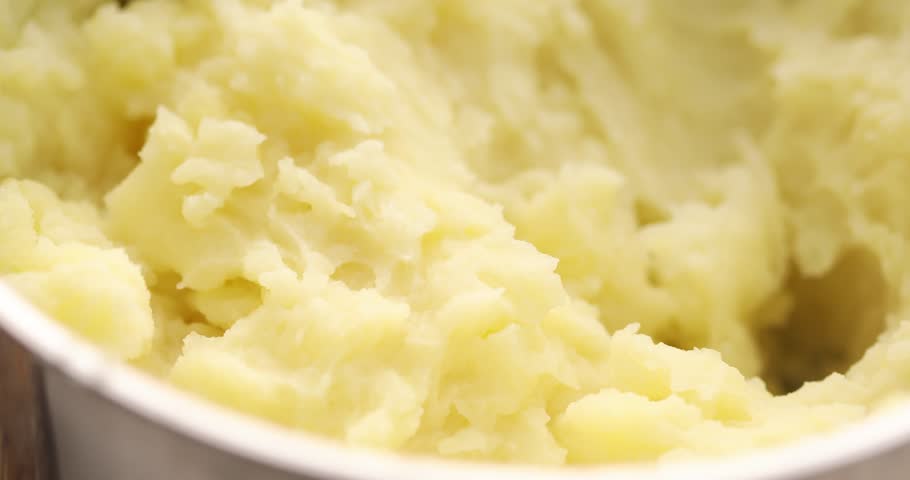 Mashing potatoes in a pot. Cooking food in the kitchen. Boiled vegetables. Vegetarian meal. Close-up.